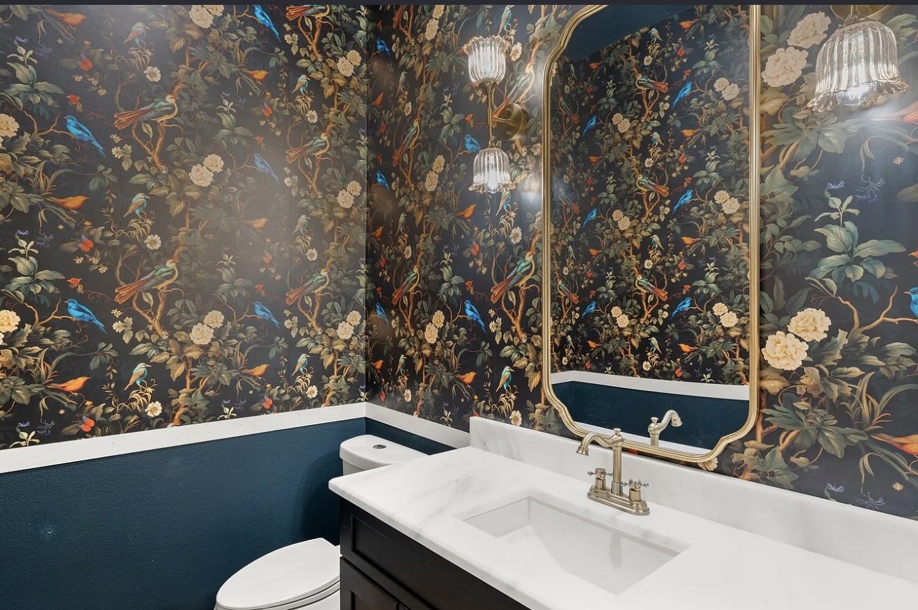 Powder bath with botanical wallpaper and brass mirror