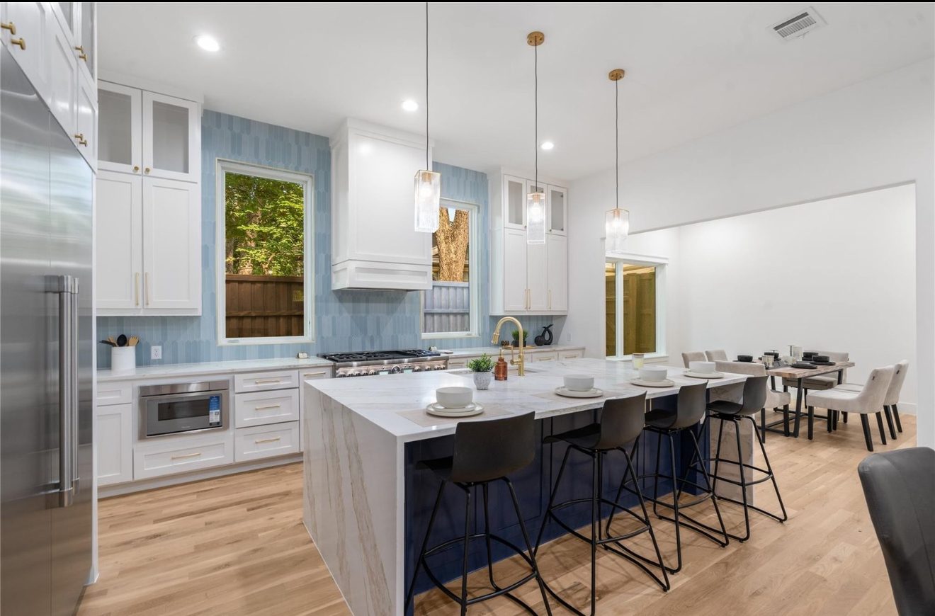 Kitchen with blue tile backsplash and navy waterfall island