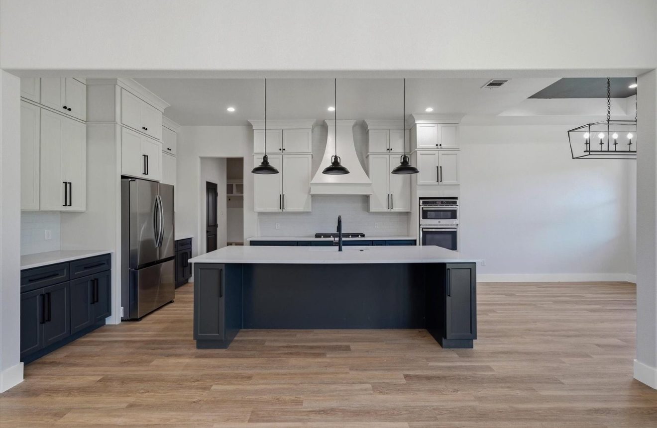 Kitchen with navy island and white cabinetry