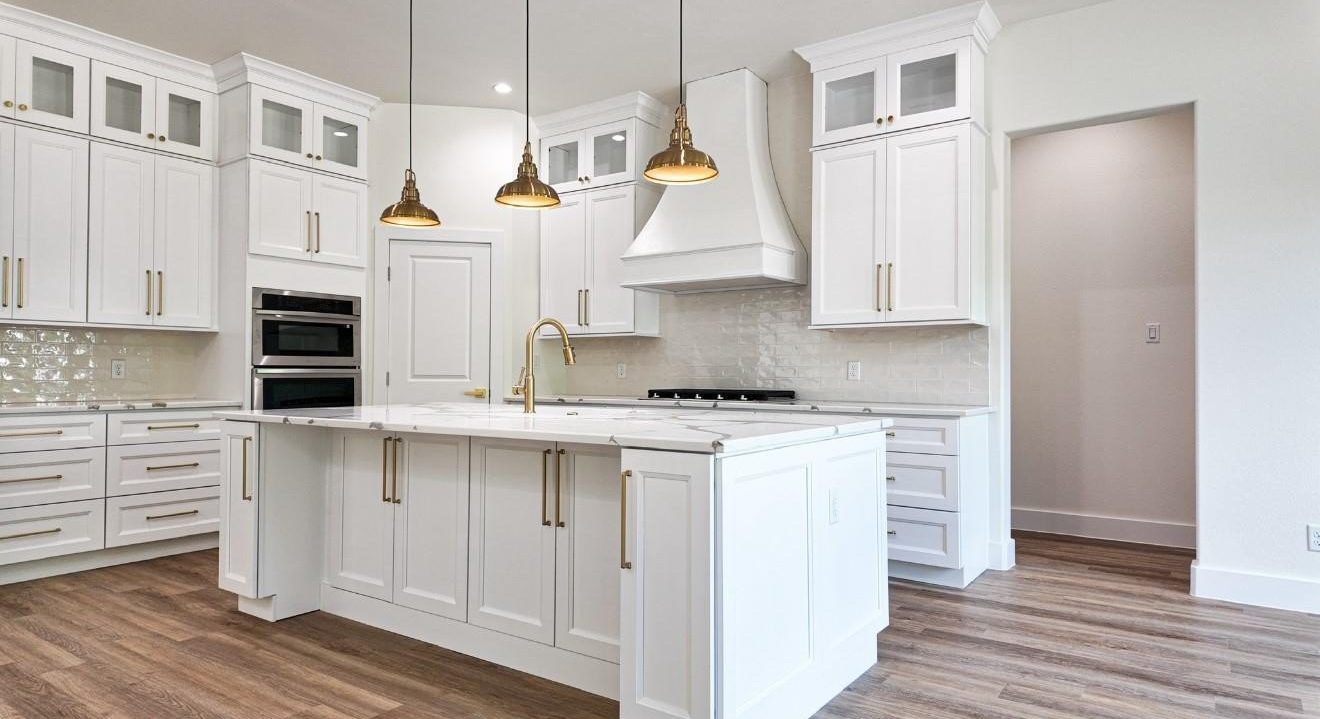 White kitchen with gold pendants and custom hood