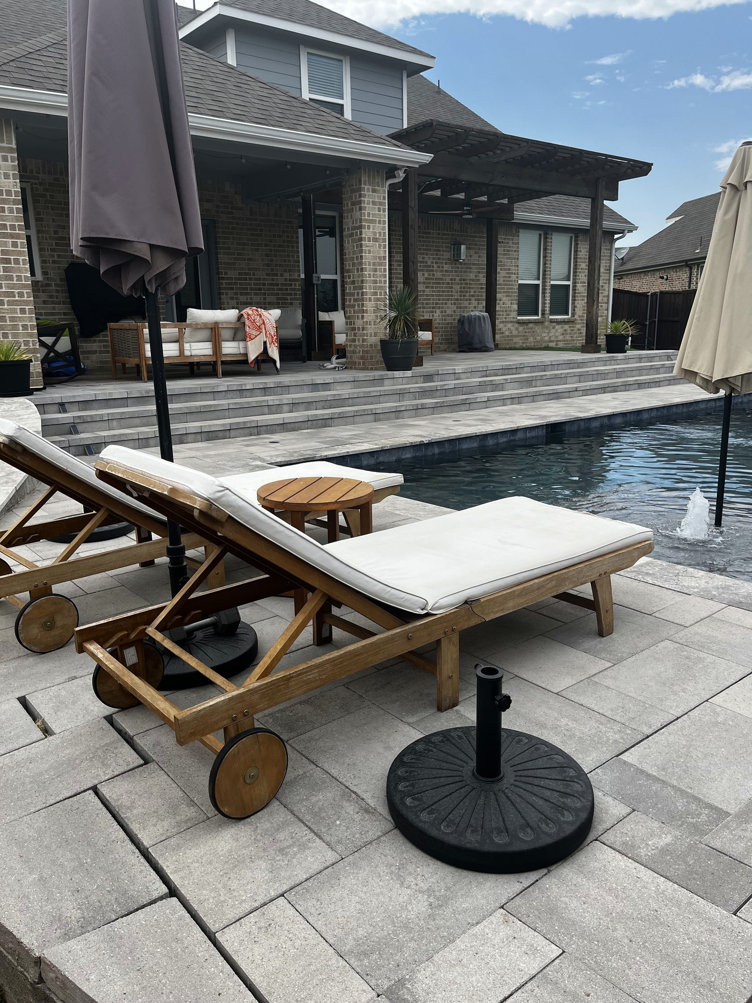Raised paver patio with steps down to the pool